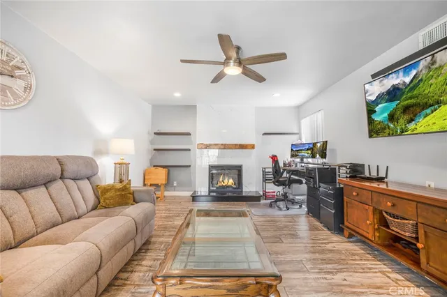 a living room with furniture a fireplace and a flat screen tv
