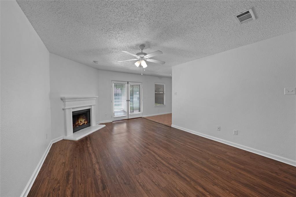 2910 Chisholm Trail Corinth, TX 76210 - Photo 5 of 30 a view of an empty room with a fireplace and a window