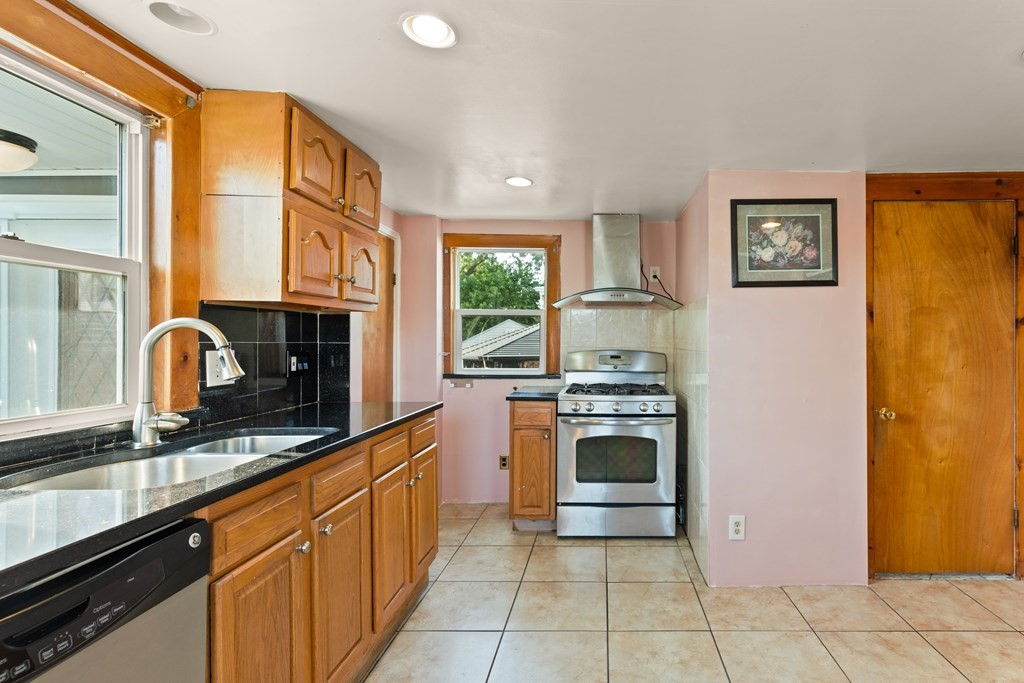 97 River Street Lynn, MA 01905 - Photo 17 of 30 a kitchen with stainless steel appliances granite countertop a stove and a sink