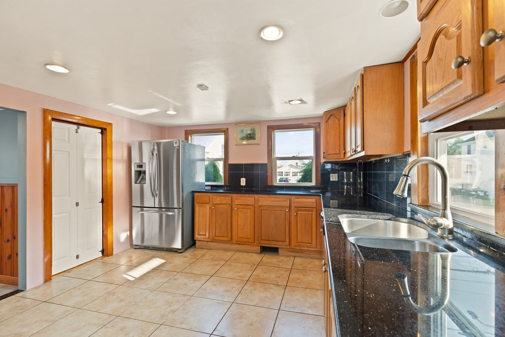 97 River Street Lynn, MA 01905 - Photo 18 of 30 a kitchen with stainless steel appliances granite countertop a refrigerator and a stove top oven