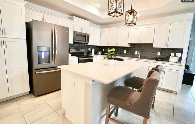 a kitchen with stainless steel appliances a stove a refrigerator and a kitchen island