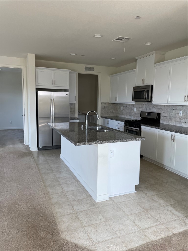 609 Trailblaze Irvine, CA 92618 - Photo 5 of 29 a kitchen with stainless steel appliances granite countertop a sink a stove a refrigerator and a microwave