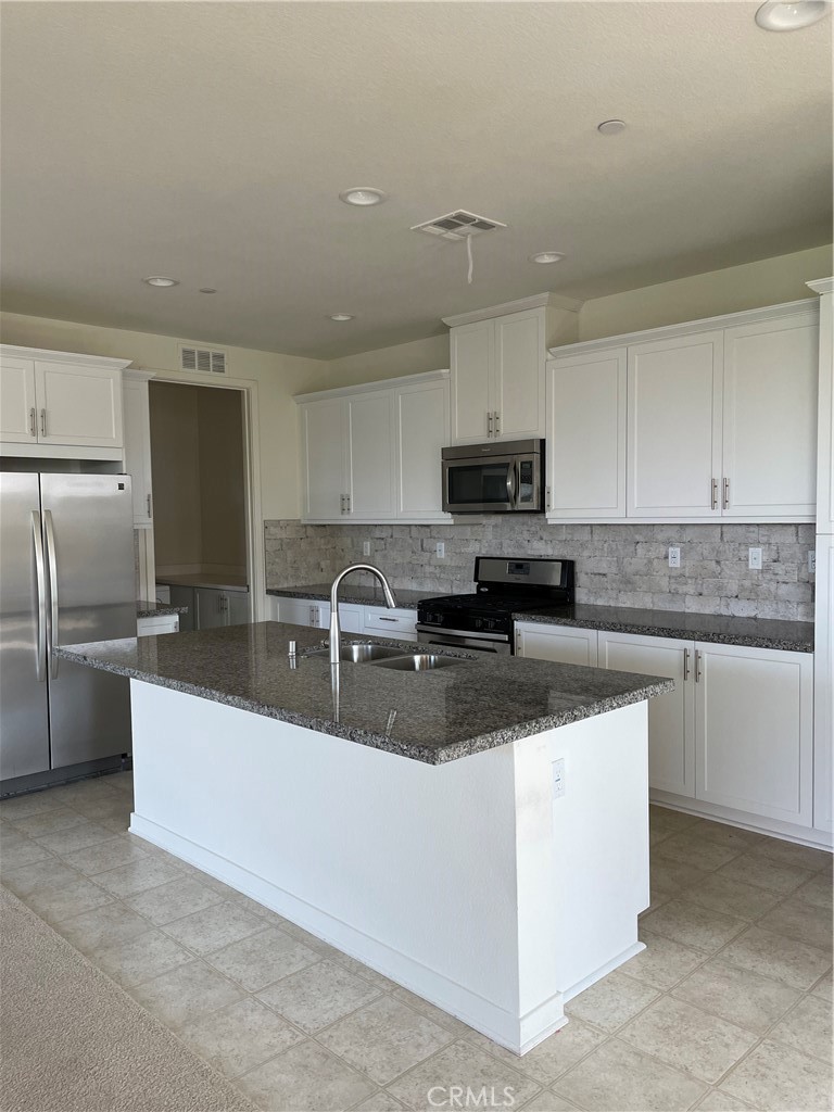 609 Trailblaze Irvine, CA 92618 - Photo 6 of 29 a kitchen with stainless steel appliances granite countertop a sink a stove and a refrigerator