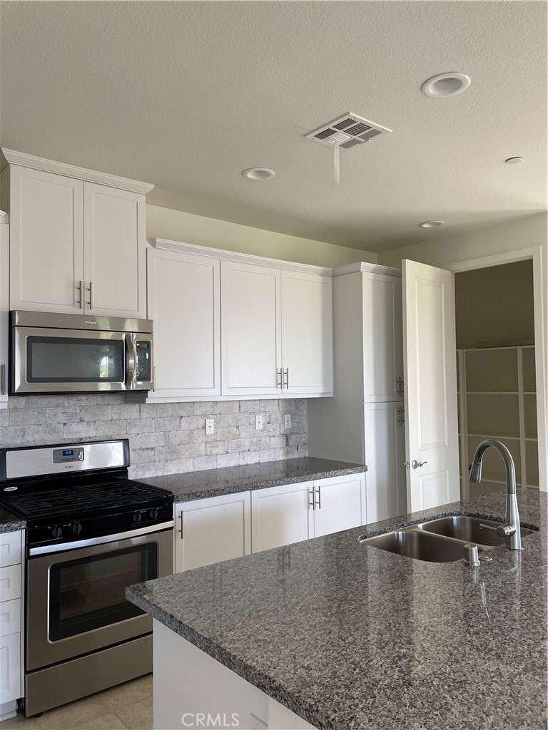 609 Trailblaze Irvine, CA 92618 - Photo 7 of 29 a kitchen with granite countertop a stove and a sink