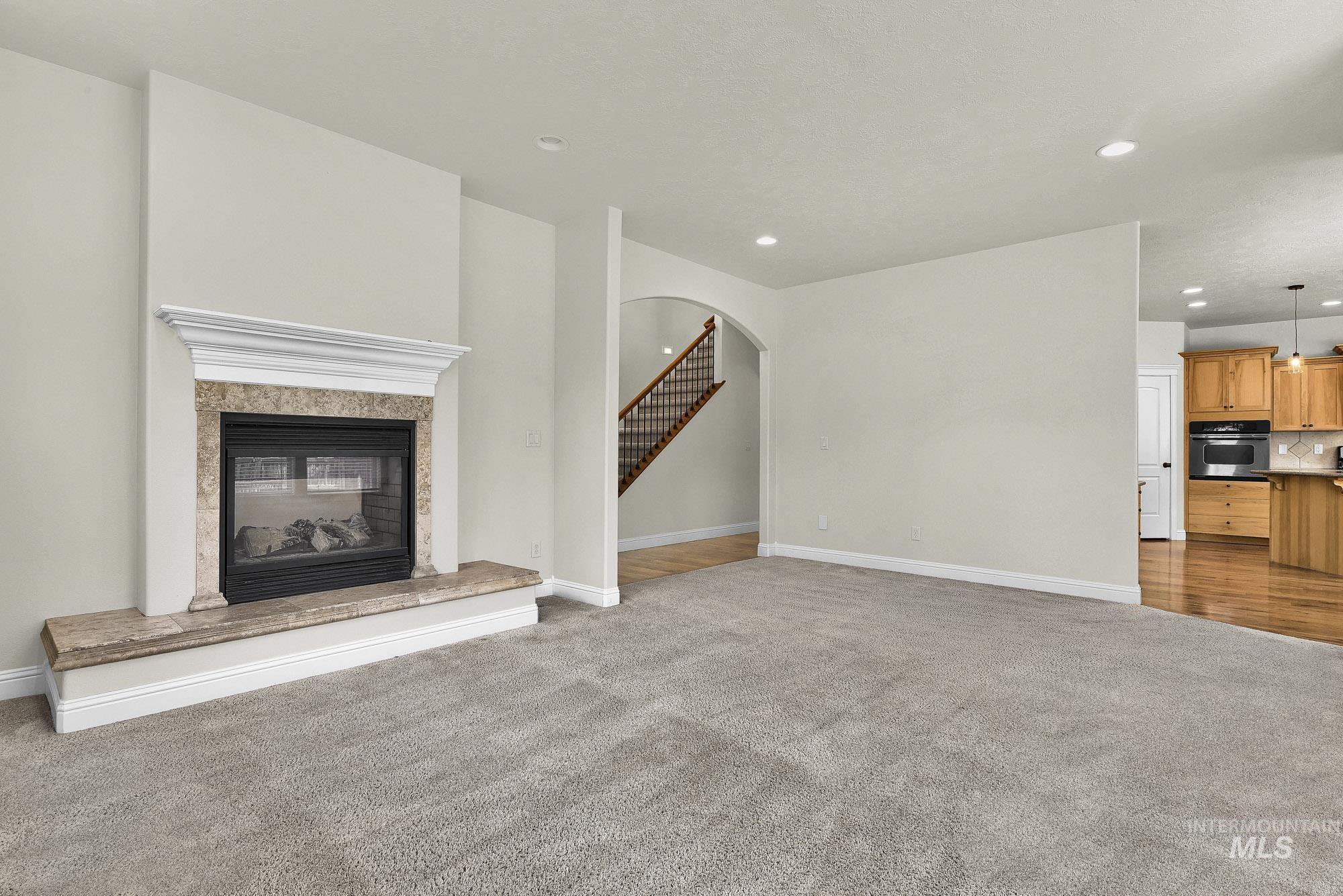 2172 West Cedar Grove Street Meridian, ID 83646 - Photo 8 of 49 Living room featuring a fireplace with a stone surround and mantel, recessed lighting, and soft carpeting