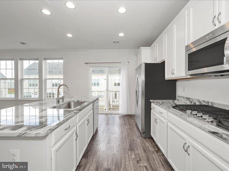 667 East Church Street, Unit B Frederick, MD 21701 - Photo 11 of 51 a kitchen with a stove a sink and a microwave