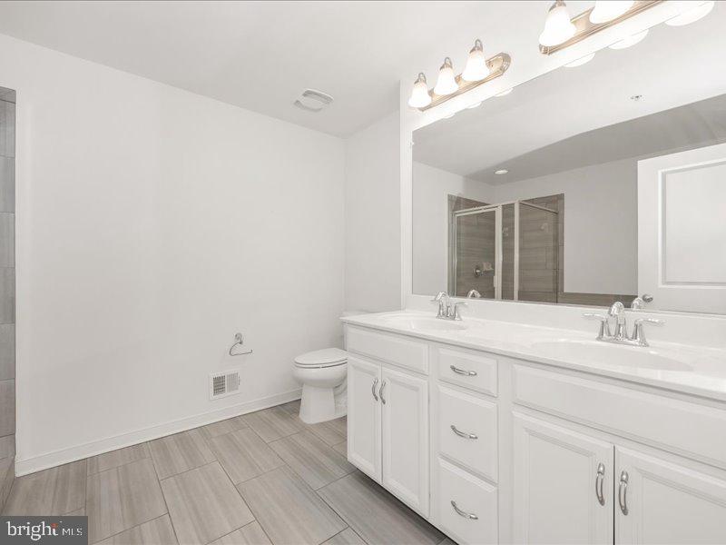 667 East Church Street, Unit B Frederick, MD 21701 - Photo 24 of 51 a bathroom with a granite countertop sink mirror and toilet