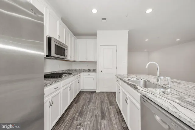 a kitchen with granite countertop a sink and steel appliances