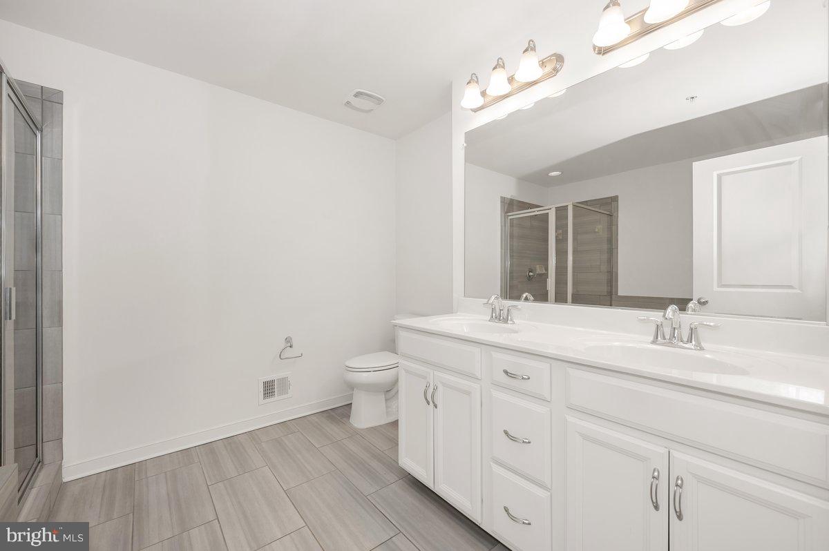 667 East Church Street, Unit B Frederick, MD 21701 - Photo 5 of 51 a bathroom with a granite countertop sink mirror and toilet