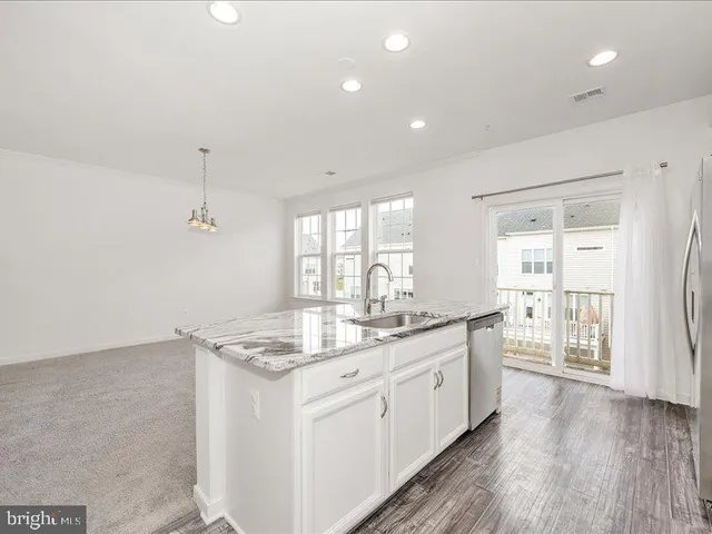 a kitchen with granite countertop a sink stove and cabinets