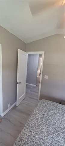 a view of a hallway with wooden floor and closet area