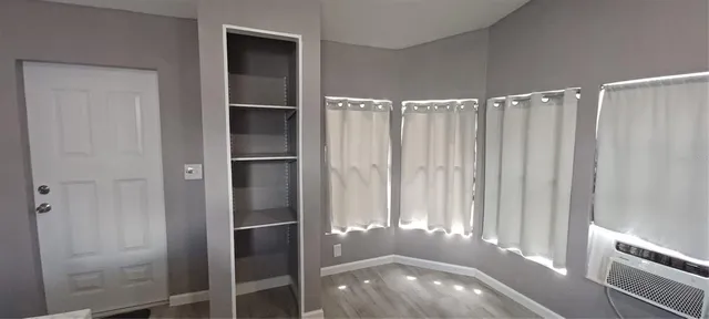 a view of a room with a chandelier fan and wooden floor