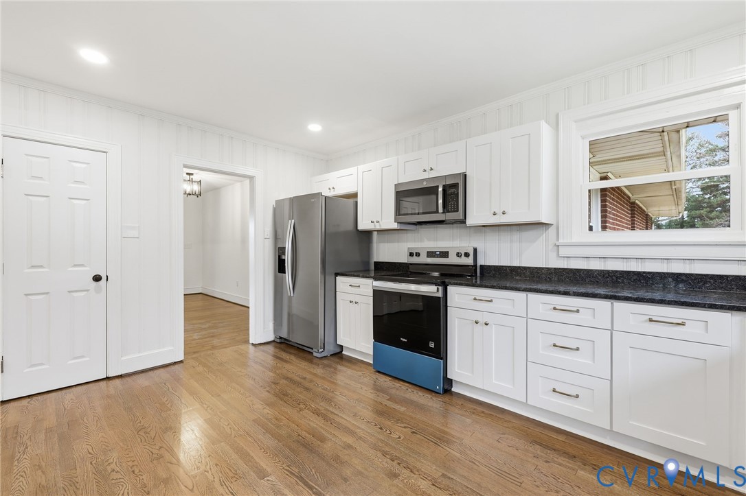 8202 Vaughan Road Petersburg, VA 23805 - Photo 13 of 31 a kitchen with granite countertop white cabinets and stainless steel appliances