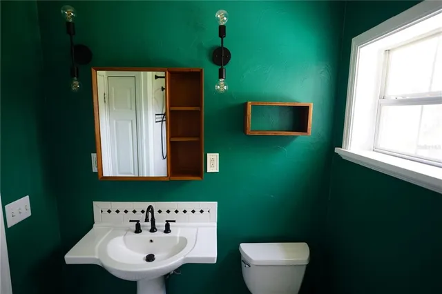 a bathroom with a toilet sink and mirror