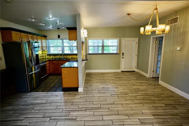 a view of a kitchen with refrigerator and a table