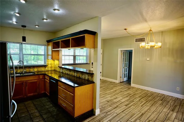 a kitchen with stainless steel appliances granite countertop a stove a sink and a refrigerator