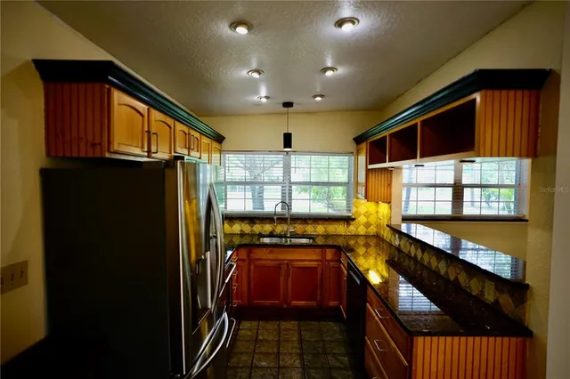 a kitchen with stainless steel appliances granite countertop a refrigerator and a stove