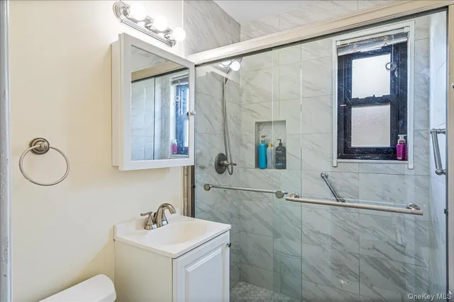 a bathroom with a sink vanity mirror and tub