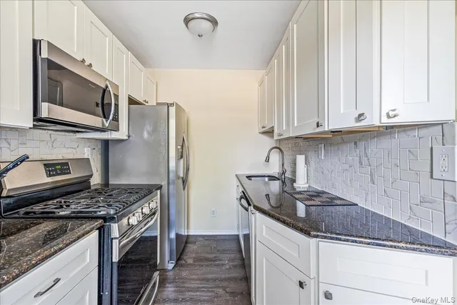 a kitchen with stainless steel appliances granite countertop a sink stove microwave and refrigerator