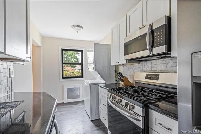 a kitchen with cabinets appliances and a window