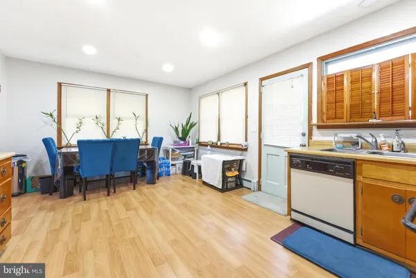 a living room with a stove a table and chairs kitchen with wooden floor