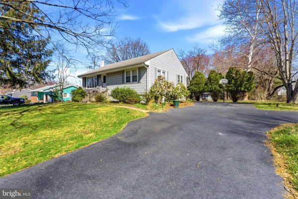 a front view of a house with a yard and trees