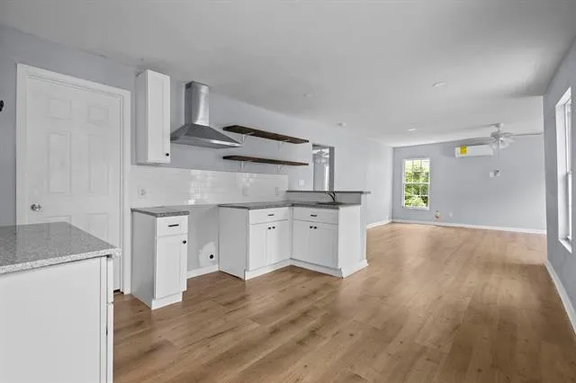 a kitchen with granite countertop a refrigerator and a stove top oven