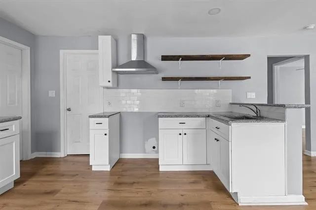 a kitchen with cabinets and wooden floor