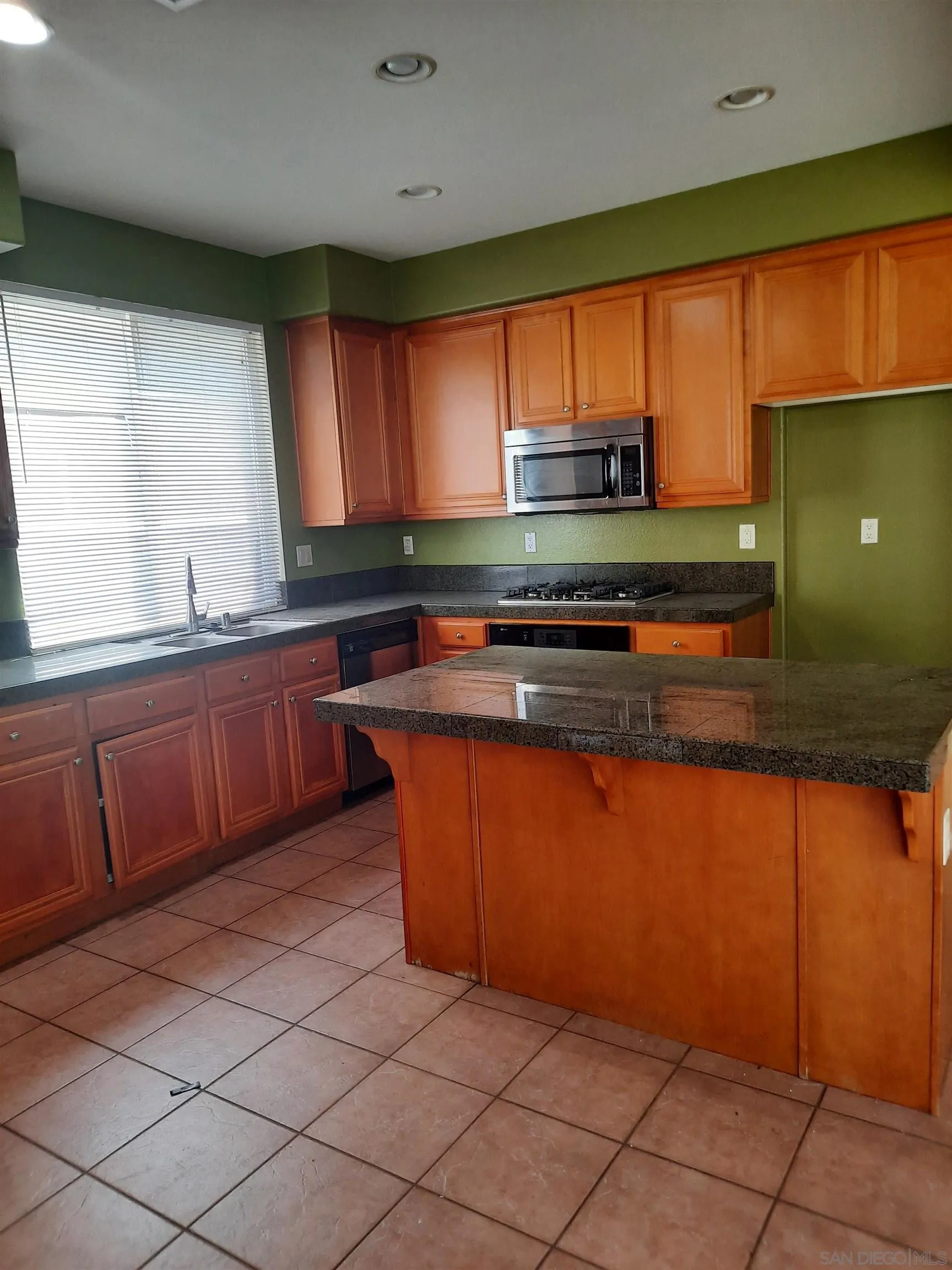 a kitchen with stainless steel appliances granite countertop a sink counter space cabinets and a large window