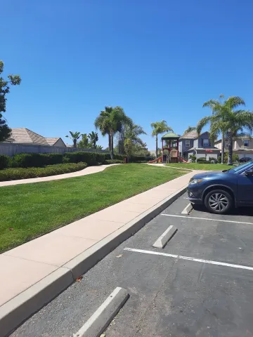 a view of a street with a car parked on the side of the road