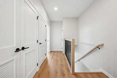 a view of a hallway with wooden floor and staircase