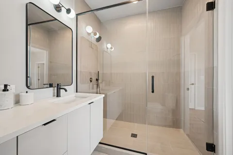 a bathroom with a shower sink vanity and mirror