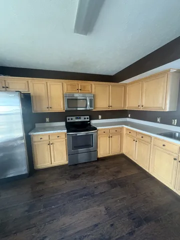 a kitchen with stainless steel appliances granite countertop a stove a sink and a granite counter tops with wooden floors