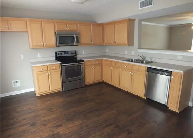 a kitchen with granite countertop a stove top oven sink and cabinets