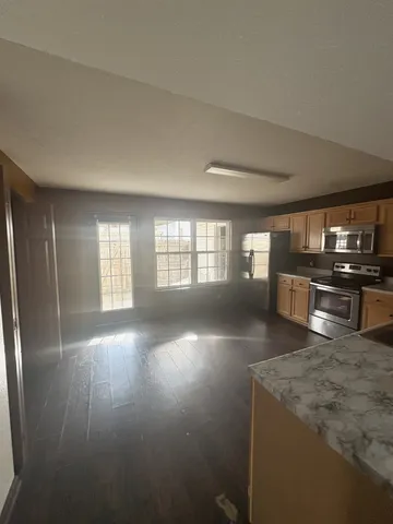 a view of a kitchen with furniture and wooden floor