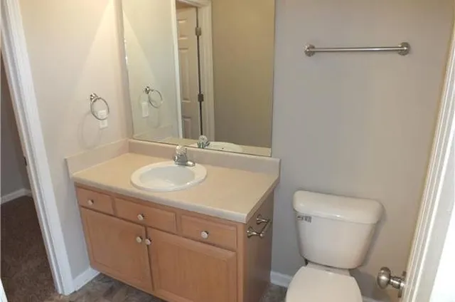 a bathroom with a toilet sink and mirror