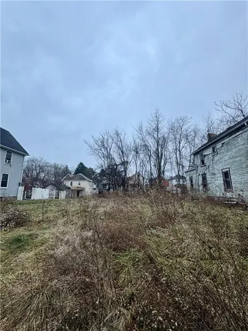 a view of a dry yard with wooden fence