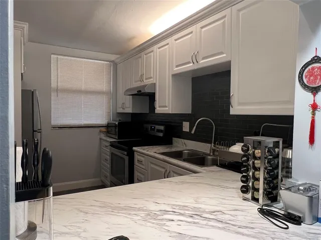 a kitchen with a sink appliances and cabinets