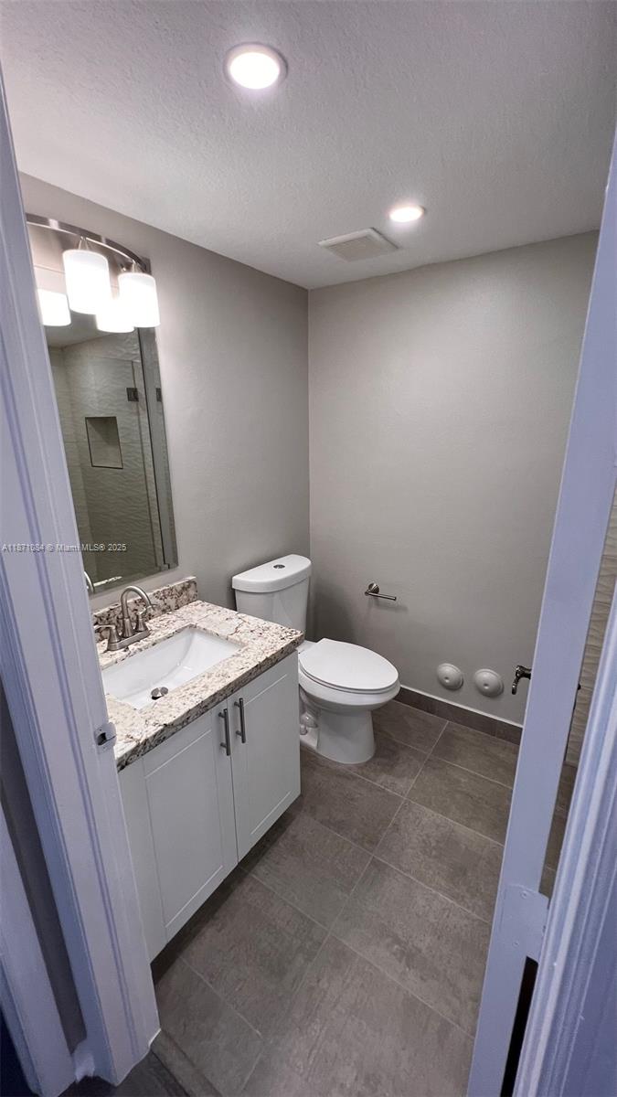 218 Northwest 12th Avenue, Unit 905 Miami, FL 33128 - Photo 13 of 15 a bathroom with a sink and mirror with toilet