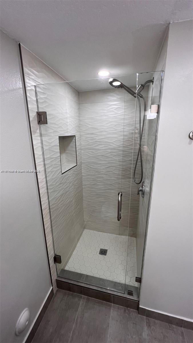 218 Northwest 12th Avenue, Unit 905 Miami, FL 33128 - Photo 14 of 15 a bathroom with a shower and a mirror