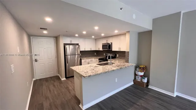 a kitchen with stainless steel appliances granite countertop a refrigerator and a stove top oven