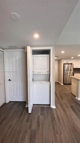 a view of a hallway with wooden floor and a cabinet