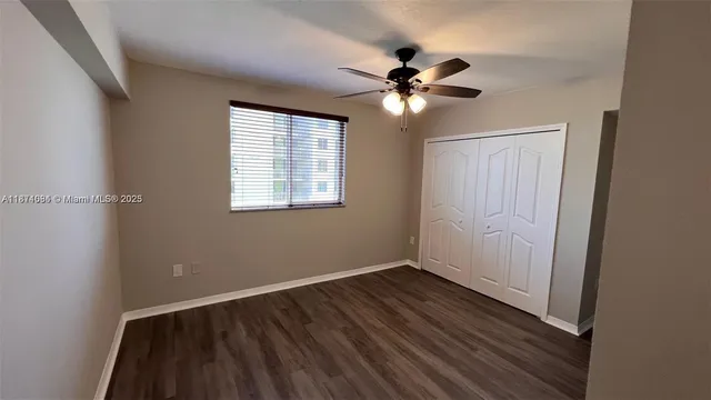 a view of a room with wooden floor and fan
