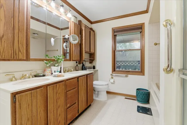 a bathroom with a double vanity sink toilet mirror and bathtub