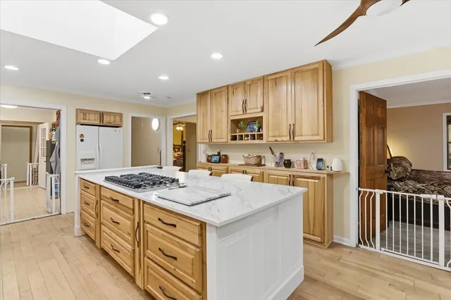 a kitchen that has a lot of white cabinets and stainless steel appliances