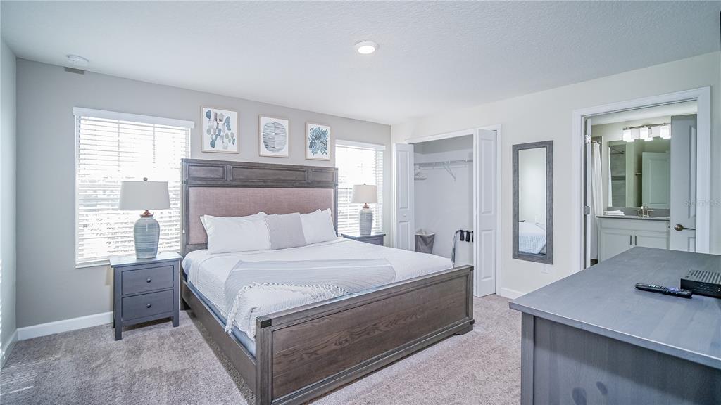 8919 Stinger Drive Davenport, FL 33896 - Photo 13 of 39 a bedroom with a large bed and a table