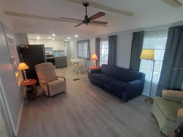 a kitchen with stainless steel appliances a refrigerator a stove a sink a dining table and chairs