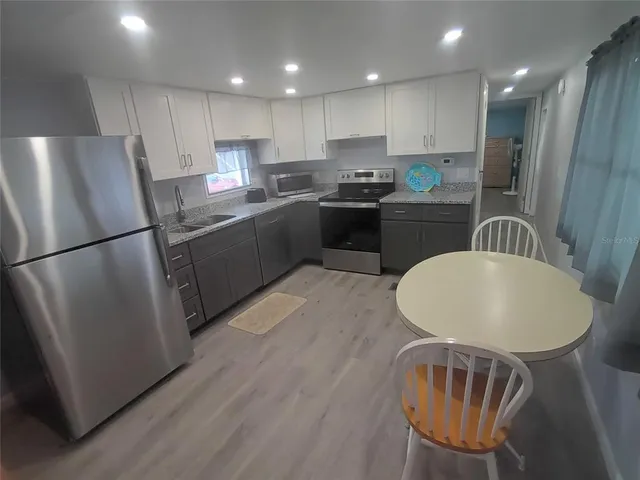 a kitchen with sink refrigerator and cabinets