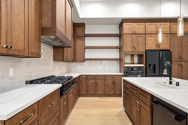 a kitchen with stainless steel appliances granite countertop a sink stove and cabinets