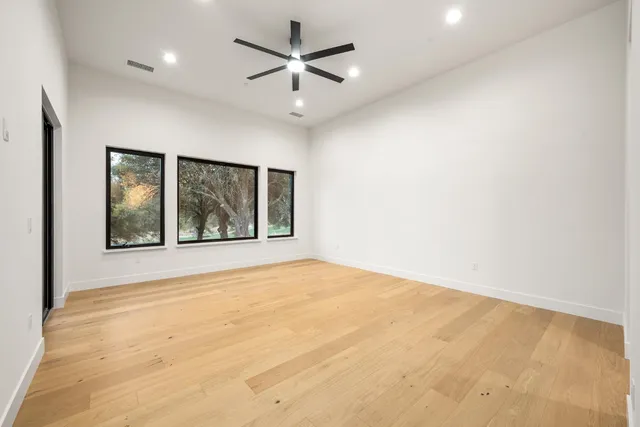 an empty room with fan and windows